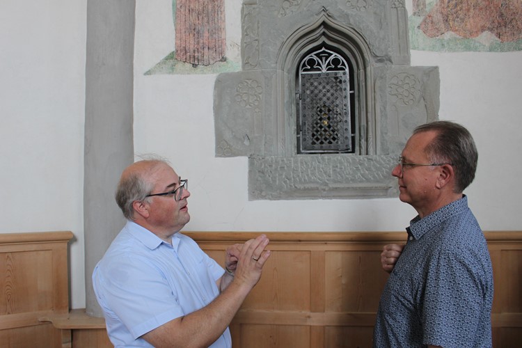 Michael Berger erläutert Phil Robinson die Bedeutung des Sakramentshäuschens in der Sennwalder Kirche.